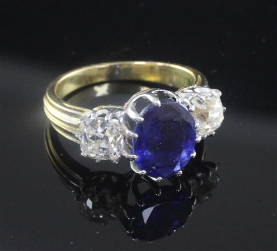 An 18ct gold and three stone sapphire and diamond ring, size M.